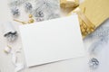 Abstract christmas background, white sheet of paper lying among small decorations on white wooden desk. Flat lay mockup Royalty Free Stock Photo