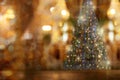 Abstract Christmas blurred bokeh background with rustic wood table in front of Christmas tree. Royalty Free Stock Photo