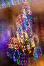 Abstract christmas neon background. Fancy Christmas tree with blurred vertical hanging glowing garlands