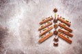 Abstract Christmas tree made of cinnamon sticks and spices. Beige grunge background. Top view, flat lay Royalty Free Stock Photo
