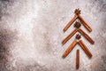 Abstract Christmas tree made of cinnamon sticks and star anise on a beige grunge background. Top view, flat lay. Noel Royalty Free Stock Photo