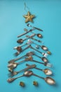 Abstract Christmas tree made from blue background. Top view . tree of knives and forks with a star Royalty Free Stock Photo