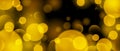 Abstract circle bokeh wallpaper. Gold yellow color blur effect on black background. Shiny golden light sparkle texture Royalty Free Stock Photo