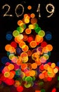 Abstract circular bokeh background of Christmas tree ight and 2019 year wrote with sparkler fireworks