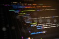 Abstract close-up of colorful programming code on dark screen, representing backend development, digital systems, data processing Royalty Free Stock Photo