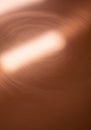 Abstract close-up of a copper-colored surface with swirling patterns. Light reflects off Royalty Free Stock Photo