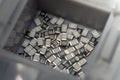 Grey scattered microscopic SMT surface mount chip resistors sorted in grey storage container