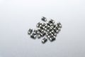 Abstract close-up of grey scattered 0402 SMT surface mount chip ferrite bead power electronics components on white background in r Royalty Free Stock Photo