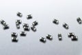 Abstract close-up of grey scattered 0402 SMT surface mount chip ferrite bead power electronics components on white background in r Royalty Free Stock Photo