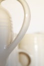 Abstract closeup of a porcelain teapot and cups. Concept of blurred white crockery and a set of kitchenware against an