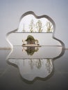Cloud?Shaped Wall Opening Framing Manicured Tree With Reflective Water Royalty Free Stock Photo