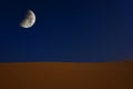 Abstract collage of a sand dune in the desert of Sudan with the moon at the dark sky