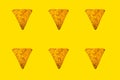 Abstract bright background of whole triangular nachos slices on yellow color Royalty Free Stock Photo