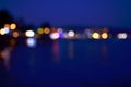 Abstract colorful bokeh effect city lights reflected over night water outdoor background. Royalty Free Stock Photo