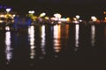 Abstract colorful bokeh effect city lights reflected over night water outdoor background. Royalty Free Stock Photo