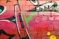 Abstract colorful fragment of graffiti paintings on old brick wall. Street art composition with parts of unwritten letters and