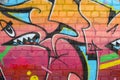 Abstract colorful fragment of graffiti paintings on old brick wall. Street art composition with parts of unwritten letters and