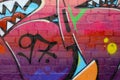 Abstract colorful fragment of graffiti paintings on old brick wall. Street-art composition with parts of wild letters and
