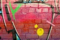 Abstract colorful fragment of graffiti paintings on old brick wall. Street-art composition with parts of wild letters and