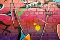 Abstract colorful fragment of graffiti paintings on old brick wall. Street-art composition with parts of wild letters and