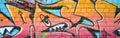 Abstract colorful fragment of graffiti paintings on old brick wall. Street-art composition with parts of wild letters and