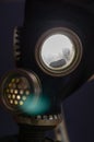 Abstract composition with a gas mask glowing from inside. Military gas mask with bright electric light in the eyepieces