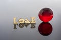 Abstract composition of love. Isolated wooden letters and glass balls Royalty Free Stock Photo