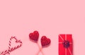 Abstract composition with two decorative hearts, lollipops and red present box on pink paper background. Valentine day theme. Love Royalty Free Stock Photo