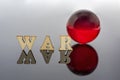 Abstract composition of war. Isolated wooden letters and red glass ball Royalty Free Stock Photo