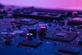 Abstract computer background with electronic device, neon colors toned. Macro photography of electronic components. Microchip, CPU