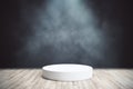 Abstract concept scene with white blank cylinder podium in the center of wooden floor at dark smoky background. Mockup. 3D