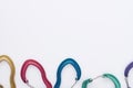 Abstract conception. Many of the multi colored carabiners on lying on the white table