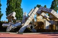 Abstract concrete cubed sculpture in tiny pond with seagulls on red brick sidewalk