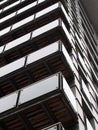 Abstract corner view of a tall modern urban apartment building with black cladding and glass balconies Royalty Free Stock Photo