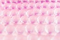 Abstract cosmetic background -  glass balls wit purple color on pastel pink backdrop. Royalty Free Stock Photo