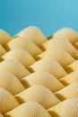 Abstract creative food concept. Dry uncooked pasta conchiglioni or conchiglie with blue background Royalty Free Stock Photo