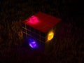 Abstract cube of cubes with emissive color cubes on a rocky surface Royalty Free Stock Photo