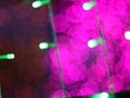 Abstract Dark Bokeh light blurred background, lightbulb on Christmas tree for celebrate season with pink, red and green colorful Royalty Free Stock Photo