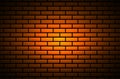 Abstract dark brick wall background illuminated by a spot