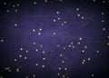 Abstract dark purple vignette with black grunge stains and shiny gold stars and empty lighter central Royalty Free Stock Photo