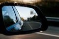 Abstract defocused blur view in the rear view mirror of a car driving on highway