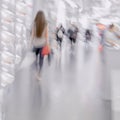 Abstract figure of girl with red bag close-up, background. Defocused motion blurred young people walking in shopping