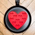 Abstract design of molds for ice in the shape of a heart lying on a frying pan Royalty Free Stock Photo