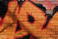 Abstract detail of urban street graffiti on old brick wall close-up. Modern vivid background