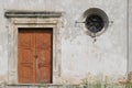 Stone wall with an old wooden door and a small window. Royalty Free Stock Photo