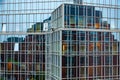 Abstract distorted reflection of house in mirrored glass wall of modern corporate building