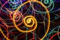 Abstract drawing of glowing multicolored spiral swirls on black background Royalty Free Stock Photo