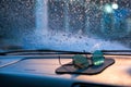 Abstract emotional picture of blurred sunglasses on the car`s console with droplets on the front glass in background