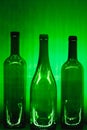 Abstract empty wine bottles with green illumination Royalty Free Stock Photo