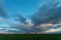 Abstract evening cloud over a green field